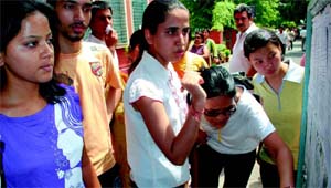 Anxious students check out the second cut-off list at Kirori Mal College in New Delhi on Tuesday.