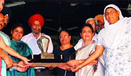 HMV Principal J. Kackeria recieves the overall championship trophy in the womens section during the annual sports prize distribution of GND University in Jalandhar.