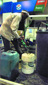 People stock petrol in New Delhi after the announcement of rise in oil prices on Wednesday.