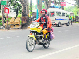 A sadhu rides a motor cycle in Dehradun on Wednesday.