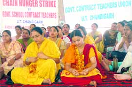 Contractual teachers on a chain fast in Sector 17, Chandigarh on Thursday.