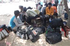 Depressed over the outcome of the recent violence at the refinery, some labourers, ready to move out, sit outside the Guru Gobind Singh Refinery in Bathinda on Friday. 