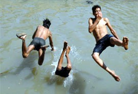 Boys take a dive in a canal during a hot afternoon in Jalandhar on Monday.