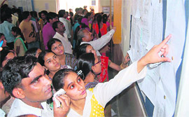 Students and parents check an admission list displayed at Government College for Girls in Gurgaon on Tuesday.