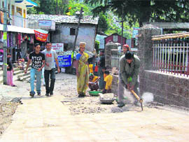 Labourers break cemented tiles near Bhagsunag Temple.