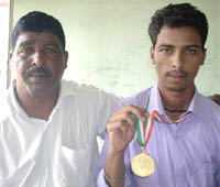Sanjeev Kumar with his father by his side displaying the gold medal that he won in the National Para championship.