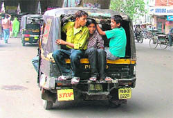Three youths enjoy a ride in an autorickshaw in Ludhiana.