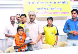 Dinesh Aggarwal, Congress MLA, honours Priyanshu Joshi in Dehradun on Friday. 