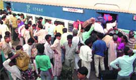 Commuters scuffle to get inside a train at a railway station in New Delhi on World Population Day