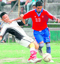 Players vie for the ball at the District Football League in Dehradun on Sunday.