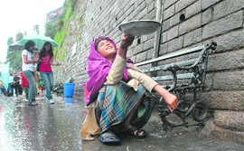 A poor boy trying to catch some hails in his paraat on the Mall in Shimla.