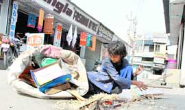 A young girl collects sawdust and small pieces of wood in a gunny bag in Jind.