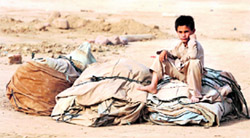 An internally displaced boy sits on a packed tent as his family prepares to go home from the United Nations High Commission for Refugees, about 140 km northwest of Islamabad, on Monday.