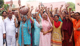 Residents stage a dharna against poor water and power supply outside the municipal corporations office in Gurgaon on Tuesday.