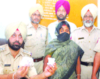 A police official shows the smack seized from a South Indian woman, Malka, in Jalandhar.