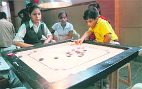 A player takes a shot during a carom tournament in Chandigarh