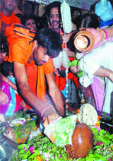 Devotees of Lord Shiva offer milk and Ganga jal on a Shivling on the occasion of Shivratri in New Delhi on Monday