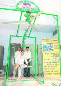 A differently abled schoolteacher, Rajesh Kumar, and his friends demonstrate the swing-operated fan he has designed in Hisar.