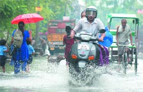 DRENCHED: People on a waterlogged street after downpour in east Delhi