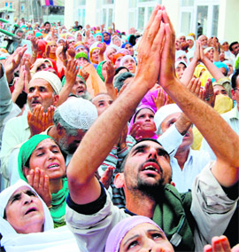 Muslims raise their hands in prayer as a head priest displays a holy relic believed to be a hair from the beard of Prophet Mohammed during special prayers on the occasion of Shab-e-Meraj at the Hazratbal shrine in Srinagar on Tuesday.