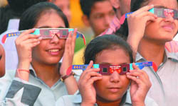 Schoolchildren watch the solar eclipse at Rajpath in New Delhi on Wednesday.