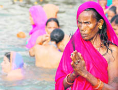 A woman prays after taking a holy dip in Brahm Sarovar during the solar eclipse in Kurukshetra on Wednesday.
