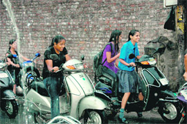 Girls enjoy a ride in the rain in Dehradun on Thursday. 