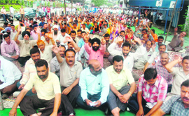 Members of the Joint Consultative Committee of the employees unions protest for implementation of the 6th Pay Commission report in Jammu on Thursday