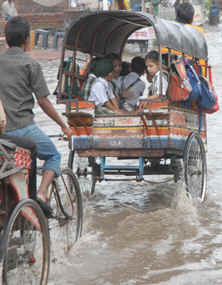 Traffic moves at a snails pace on the GT Road in Jalandhar on Thursday. Schoolchildren in vans pass through waterlogged streets.