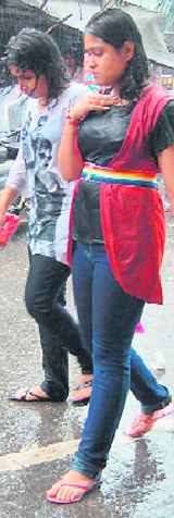 Two young girls, all drenched, enjoy the rainfall while on a visit to Paltan Bazar.