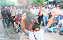 Members of the central university joint action committee burn an effigy of the state government in front of Jammu University on Friday.