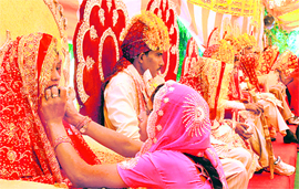 A relative helps a bride with her make-up at a mass marriage function organised by the Manav Seva Sangh at Karna Park in Karnal on Sunday.