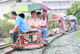 Dangerous trick: Commuters ride a foot-powered trolley on a railway track in Manila