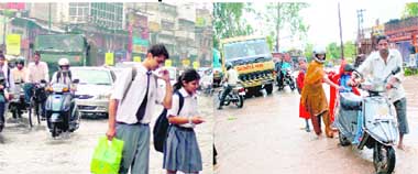 Major traffic jams were witnessed on the main Rajpur road in Dehradun following a downpour on Monday; and (right) a family pushes their scooter through a waterlogged road.