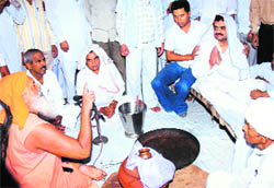 The head priest of Mukams Bishnoi Mandir (wearing saffron robe) reinducts former Deputy Chief Minister Chander Mohan into the Bishnoi sect in Hisar on Tuesday.