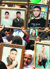Palestinians hold up pictures of relatives during a protest in Ramallah for the release of prisoners from Israeli jails on Tuesday.