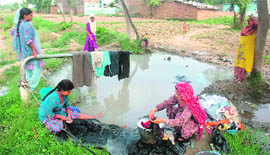 Women wash clothes at a borewell outside Talgarh village. 