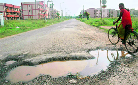 A potholed road in need of repair near the Goodwill Enclave Society in Sector 49, Chandigarh.
