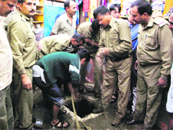 Cops pulling out bodies of three men who died cleaning the septic tank on Thursday night. 