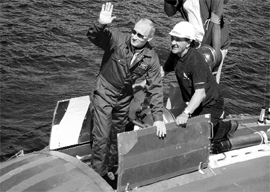 Russia's Prime Minister Vladimir Putin (L) waves aboard Mir-2 mini-submersible on which he intends to dive into the depths of Lake Baikal. The judo black belt, who has already conquered the skies in a fighter aircraft, will descend 4,600 ft below the surface of the world's deepest lake to inspect valuable gas crystals.
