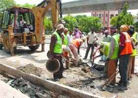 Workers repair a portion of the BRT corridor in South Delhi on Sunday morning
