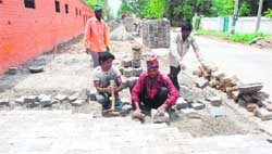 The construction of a footpath in progress on the Minar Road in Karnal.