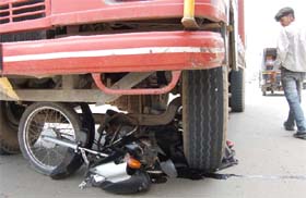 A motorcycle lies under a truck after a head-on collision between two vehicles on Express Highway No. 8 near Gurgaon