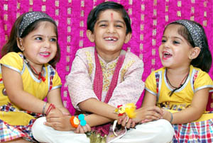 Twins tie rakhi on their brothers hands on the eve of Rakshabandhan in Jalandhar on Tuesday.