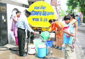 Residents of Joshi Nagar queue up to fetch water from a tanker.