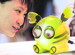 A girl talks to a robot, called "Instant Messenger Robot," on display at the International Robot Show in Taipei on Wednesday. The robot can connect with the Microsoft messenger software and the user will be able to send messages by talking to the robot.
