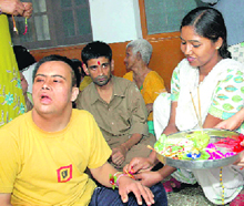 A girl ties a rakhi on the wrist of an inmate of Cheshire Home in Dehradun on Wednesday.