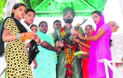 Sisters of a martyr tying a rakhi on their brothers statue.