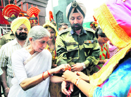 Health Minister Laxmi Kanta Chawla (left) ties rakhi to a BSF jawan at Attari  check post near Amritsar on Wednesday.