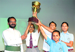 Winners of a debate contest with their trophy at St Josephs Academy in Dehradun